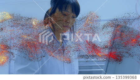 Examining holographic red and gold particle projection, researcher in lab coat in lab with laptop Examining holographic red and gold particle projection, researcher in lab coat in lab with laptop 135399368