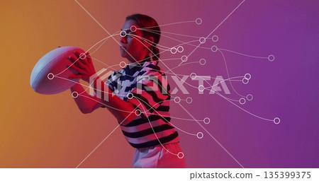 Adult athlete wearing striped rugby jersey preparing to pass rugby ball in studio, keypoint markers Adult athlete wearing striped rugby jersey preparing to pass rugby ball in studio, keypoint markers 135399375