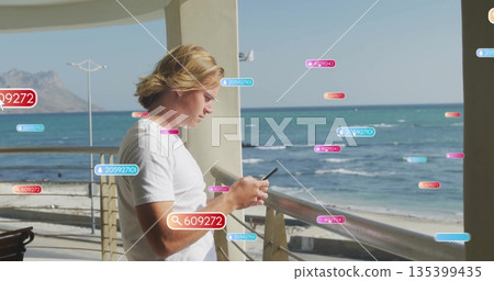 Leaning on railing man wearing white shirt checking smartphone on balcony, with floating labels 135399435