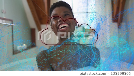 Laughing woman soaking in foamy bathtub in bathroom, with blue particles and red cloud outline 135399505