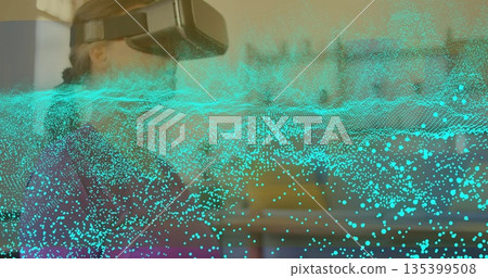 Woman wearing VR headset exploring data field in softly lit room with turquoise overlay, copy space 135399508