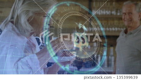 Tapping senior woman and smiling senior man examining glowing Bitcoin interface at wooden counter Tapping senior woman and smiling senior man examining glowing Bitcoin interface at wooden counter 135399639