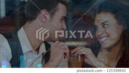 Smiling couple leaning forward and sharing tall glass with two straws at wooden bar counter 135399642