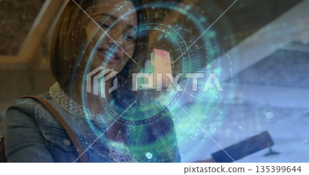 Woman wearing denim jacket and white lace top exploring AR interface above smartphone in demo area 135399644