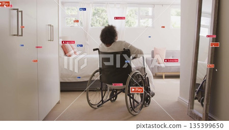 Sitting senior woman gazing through multi-pane window in bedroom, with wheelchair 135399650