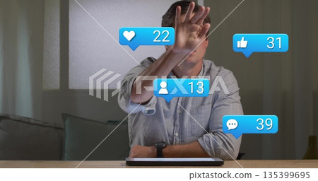 Blocking face, grey shirted man viewing social media alerts on tablet at home with smartwatch 135399695