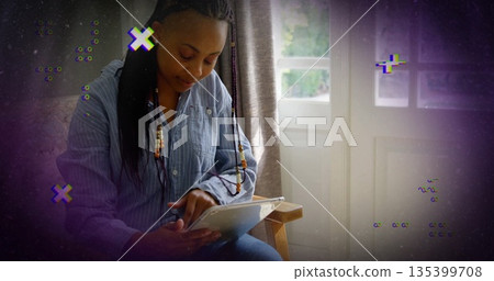 Mid adult woman tapping tablet screen on wooden chair by window, with glitch overlays, copy space Mid adult woman tapping tablet screen on wooden chair by window, with glitch overlays, copy space 135399708