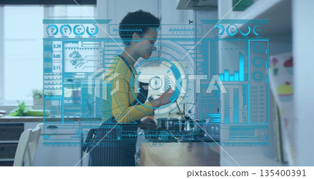 Woman in yellow top and apron stirring pot in home kitchen, interacting with holographic interface 135400391