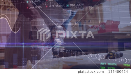 Operating masked craftsman using cordless drill on wooden plank at bench, with digital overlays 135400424