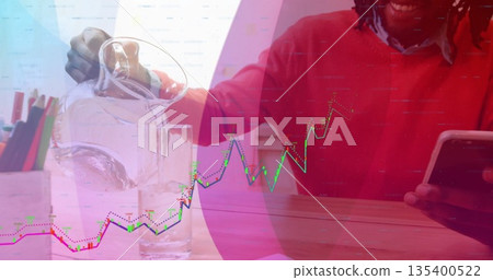 Pouring water into glass, man in red sweater holding tablet at desk, colored pencils, graph overlay Pouring water into glass, man in red sweater holding tablet at desk, colored pencils, graph overlay 135400522