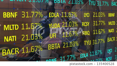 Office professionals reviewing percentages in conference room, with laptops, coffee mugs, display 135400528