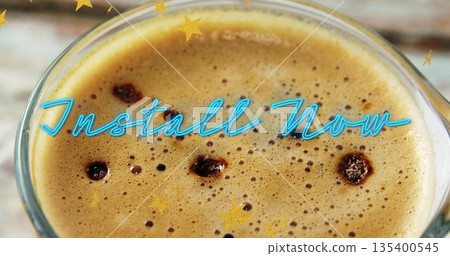 Showing glass coffee cup with frothy crema bubbles on counter with neon Install Now golden stars Showing glass coffee cup with frothy crema bubbles on counter with neon Install Now golden stars 135400545