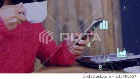 Sipping mug, checking phone, woman in red knit at wooden table, laptop, financial icons, copy space Sipping mug, checking phone, woman in red knit at wooden table, laptop, financial icons, copy space 135400554