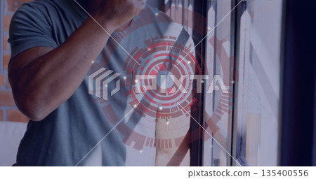 African American man tasting soup with metal spoon at kitchen window by exposed brick, copy space 135400556
