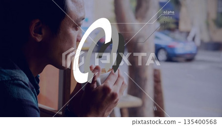 Holding mug and sipping coffee, Asian man gazing through cafe window, digital overlay, copy space 135400568