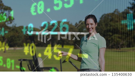 Standing golfer holding golf club beside golf cart on fairway, showing ticker overlay, copy space 135400630