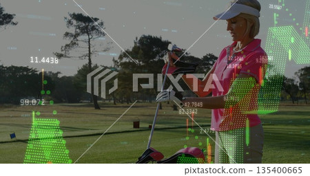 Arranging clubs in golf bag by female golfer on fairway, with floating data overlays, copy space 135400665