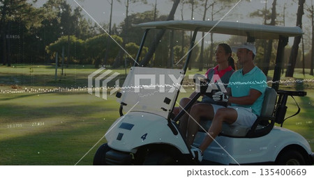 Driving man wearing golf glove steering electric golf cart on fairway, with woman in pink polo 135400669
