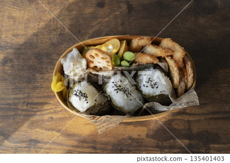 Japanese bento box with 3 rice balls and colorful side dishes 135401403