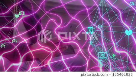 Man holding smartphone and sitting on sofa in living room, with neon magenta waves, cyan icons 135401925