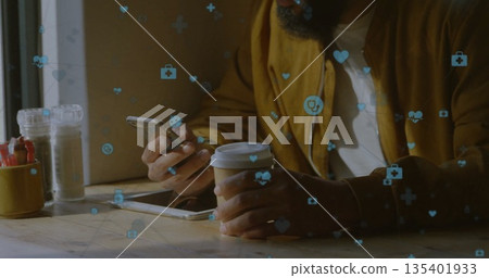 Bearded man holding smartphone and coffee cup at coffee shop table, with health icons, copy space 135401933