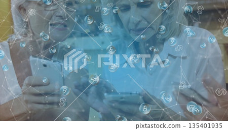 Three senior women tapping smartphone screens in home living room, with digital currency network Three senior women tapping smartphone screens in home living room, with digital currency network 135401935