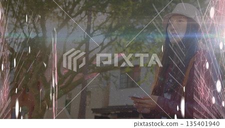 Standing Asian woman wearing hat and jacket holding smartphone on walkway, vintage film, copy space Standing Asian woman wearing hat and jacket holding smartphone on walkway, vintage film, copy space 135401940