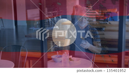 Sitting mature man eating meal at coffee shop behind perforated glass, with bowl and water bottle Sitting mature man eating meal at coffee shop behind perforated glass, with bowl and water bottle 135401952