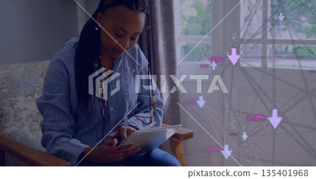 Holding white tablet woman in striped shirt sitting in armchair by window, with network overlay Holding white tablet woman in striped shirt sitting in armchair by window, with network overlay 135401968