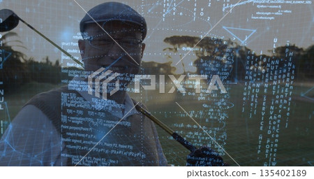 Chinese golfer shouldering golf club in flat cap at course sunset, with digital code overlay 135402189