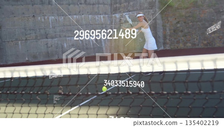 Swinging tennis player wearing dress, visor behind net, with racket, ball data overlays, copy space Swinging tennis player wearing dress, visor behind net, with racket, ball data overlays, copy space 135402219