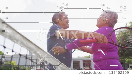 Celebrating senior couple in athletic outfits embracing on tennis court, with rackets and ball Celebrating senior couple in athletic outfits embracing on tennis court, with rackets and ball 135402309