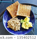 Avocado and scrambled eggs on toasted bread 135402512