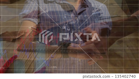 Holding smartphone, Black carpenter viewing line chart on workshop bench with tools in pocket 135402740