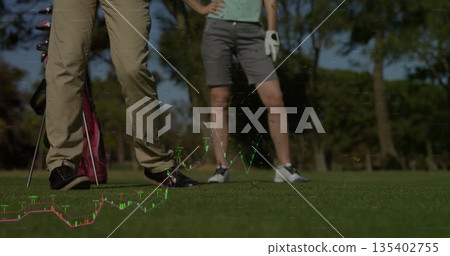 Standing couple wearing golf attire on golf course fairway, with golf bag, clubs, and glove Standing couple wearing golf attire on golf course fairway, with golf bag, clubs, and glove 135402755