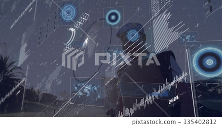 Standing Asian male with AR headset interacting with floating map panels at park dusk, copy space 135402812