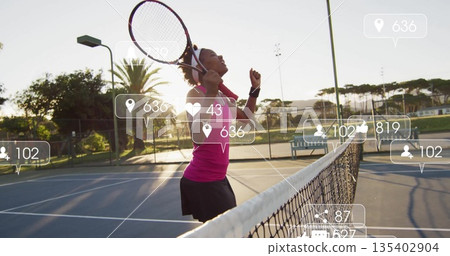 Celebrating tennis player holding racquet over shoulder near net on blue court with digital icons 135402904