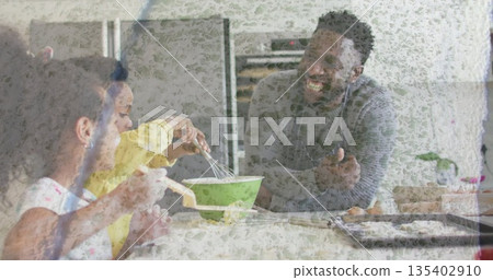 Mixing father and children stirring batter at kitchen island, with green mixing bowl and pastries Mixing father and children stirring batter at kitchen island, with green mixing bowl and pastries 135402910