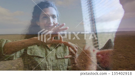Gesturing adult woman communicating through sign language near window vertical blinds, scrubland 135402918
