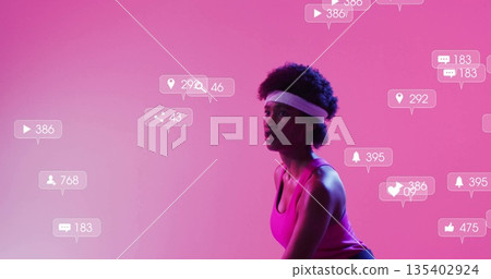 Squatting woman wearing pink activewear in studio with floating social media icons, copy space Squatting woman wearing pink activewear in studio with floating social media icons, copy space 135402924