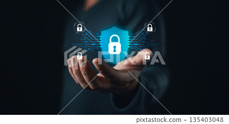 A person holds a glowing digital shield with a padlock icon surrounded by connected locks, symbolizing cybersecurity,data protection,privacy,network safety,and secure technology solutions. A person holds a glowing digital shield with a padlock icon surrounded by connected locks, symbolizing cybersecurity,data protection,privacy,network safety,and secure technology solutions. 135403048