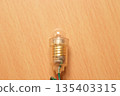 Photo of a miniature light bulb on a desk 135403315