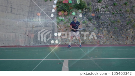 Holding mature male wearing shirt, beige shorts preparing swing on green tennis court, with racket Holding mature male wearing shirt, beige shorts preparing swing on green tennis court, with racket 135403342
