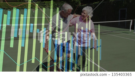 Standing senior couple embracing shoulders holding rackets at outdoor hardcourt, showing bar charts 135403365