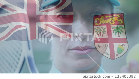 player wearing polo shirt serving racket and ball in court with Union Jack Fijian shield overlays 135403398