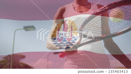 Standing tennis player in skirt and top gripping racket at court, with flag overlay, lamp posts Standing tennis player in skirt and top gripping racket at court, with flag overlay, lamp posts 135403413