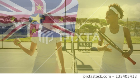 Smiling tennis players holding racket and ball at net on outdoor hard court, with flag overlay 135403418