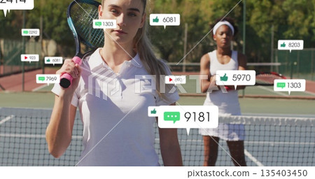 Posing female tennis player with racket over shoulder on court by net, with social media icons Posing female tennis player with racket over shoulder on court by net, with social media icons 135403450