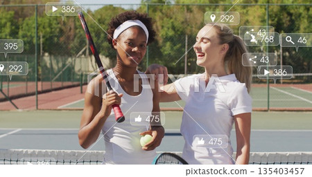 Standing two tennis players holding rackets and balls on outdoor tennis court, with media overlays Standing two tennis players holding rackets and balls on outdoor tennis court, with media overlays 135403457