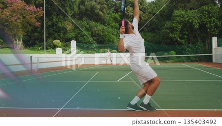 Serving tennis player hitting ball at right baseline on hardcourt, with racket, net, copy space Serving tennis player hitting ball at right baseline on hardcourt, with racket, net, copy space 135403492